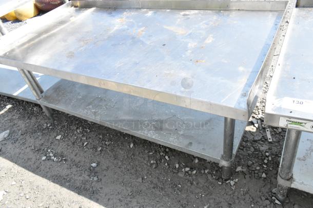 Regency stainless steel equipment stand with metal under shelf, showing signs of use. Visible Regency label on the side.
