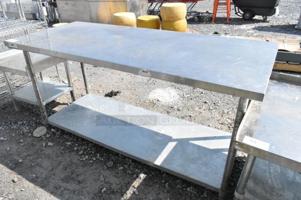 Regency stainless steel table with metal under shelf, outdoor setting, sturdy construction, visible wear, inspection labels present.