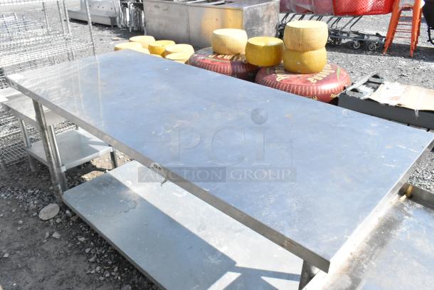 Regency stainless steel table with metal under shelf; features durable construction, visible wear; ideal for industrial use.