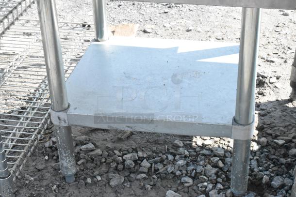 Regency 600ES2424G stainless steel equipment stand with metal under shelf; durable construction, slight wear visible.