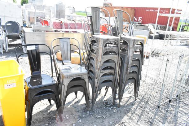19 stackable Tolix-style chairs, black and gray metal, slight wear, auction tags indicate lot numbers.