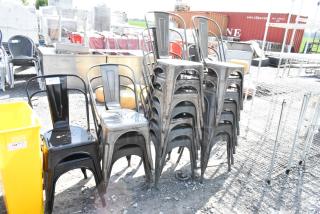 19 stackable Tolix-style chairs, black and gray metal, slight wear, auction tags indicate lot numbers.