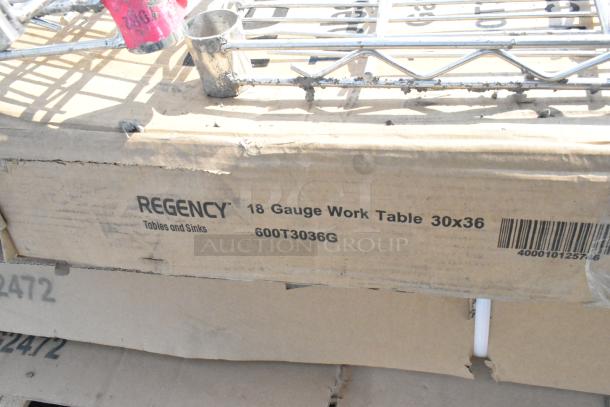 Cardboard box marked "Regency 18 Gauge Work Table 30x36," part of a new scratch and dent auction lot.