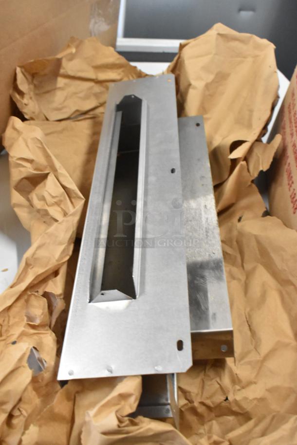 Stainless steel components, likely from a Blodgett DFG100 convection oven, are shown unboxed on crumpled paper.