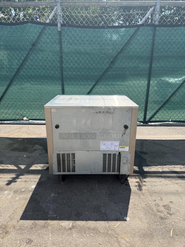 Commercial stainless steel undercounter refrigerator, 2-drawer, exterior wear, ventilation grates, size unknown.