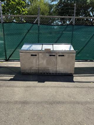 Delfield Model 4472M-30M-A1 stainless steel 72in 3-door refrigerated sandwich prep table, shown outdoors, in used condition.