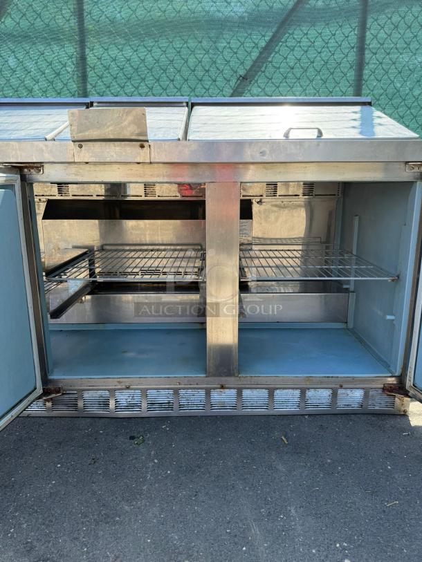 Delfield Model 4472M-30M-A1 72in stainless steel 3-door mega top refrigerated sandwich prep unit, open doors, interior shelving.