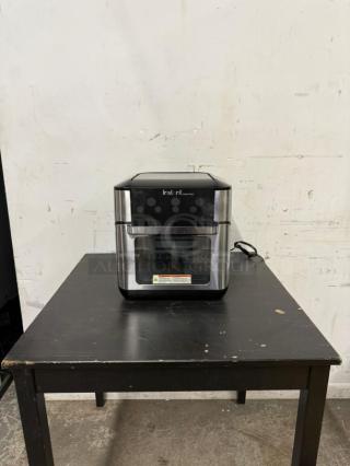 Instant Pot Vortex Plus 10 Air Fryer Toaster Oven Combo, black/stainless, 7-in-1, 1500W, on a table, in good condition.
