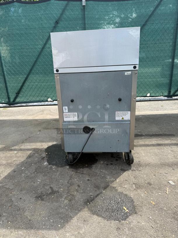True TSSU-27-12M-C-HC refrigerated sandwich prep table back view, shows wheels and power cord.