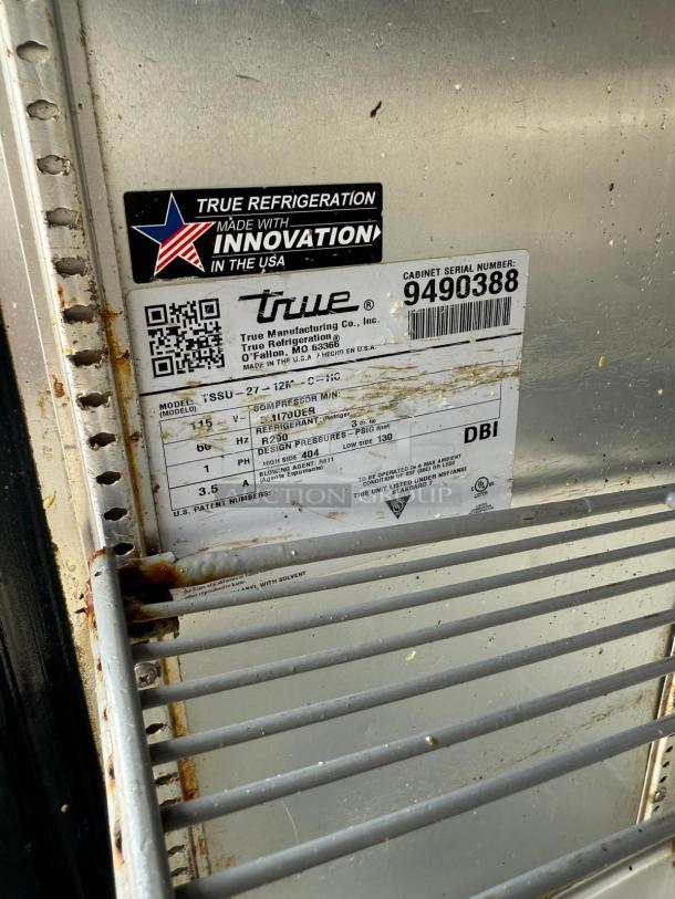 True TSSU-27-12M-C-HC prep table label detailing model, serial number 9490388, and specs. Interior shelf visible.