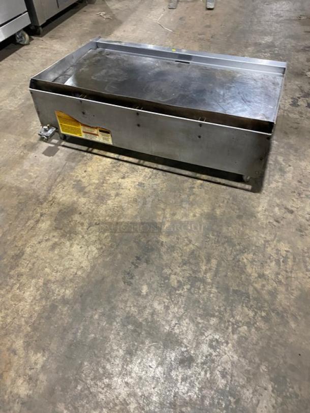 Wolf commercial stainless steel countertop flat griddle, natural gas powered, with back and side splash, on legs. Used condition.