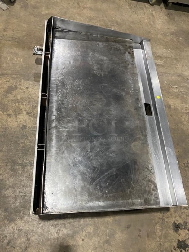 Wolf stainless steel natural gas countertop griddle, with back and side splash, mounted on legs. Appears used.