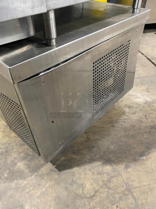 Commercial stainless steel 2-drawer refrigerated low boy, chef base on casters. Features a vented panel, sturdy condition.