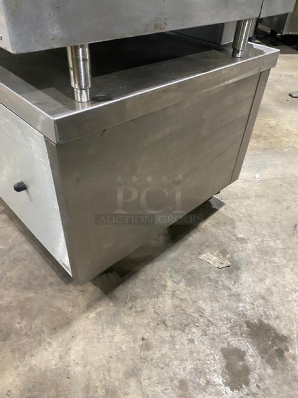 Commercial stainless steel 2-drawer refrigerated chef base on casters, sturdy construction, features pull handles and wheels.