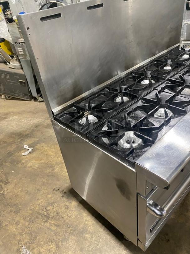 American Range commercial stainless steel 10-burner gas range with double ovens, backsplash, and casters. Wired oven racks included.
