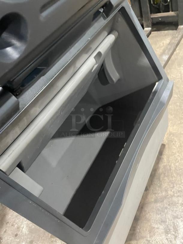 Manitowoc SD0303W stainless steel ice making machine with a lift-style bin door shown open. Electric, water-cooled, on legs.
