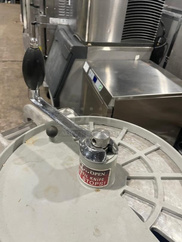 Hobart commercial chopper/mixer with stainless steel tilting bowl, cover, and handle on legs and casters; in industrial setting.