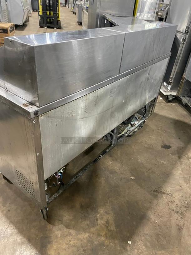 True TSSU-72-30M-B-ST 3-door stainless steel refrigerated prep table with poly-coated wire racks on casters.