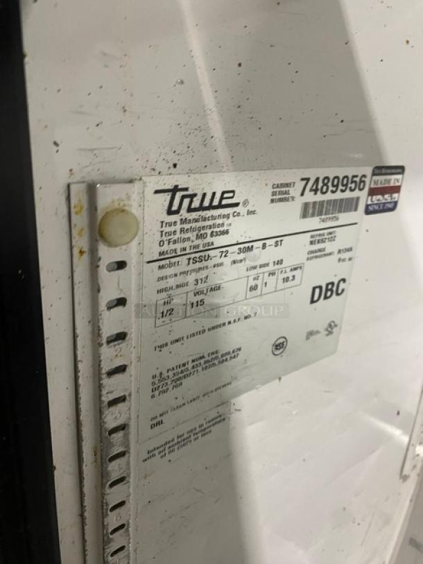 True stainless steel prep table, Model TSSU-72-30M-B-ST, tag shows SN 7489956, with specs and electrical details, on casters.