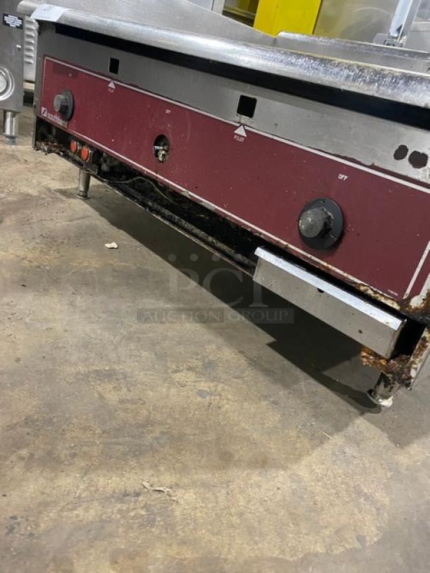 Southbend stainless steel natural gas countertop flat griddle with back and side splash, on legs. Visible wear.