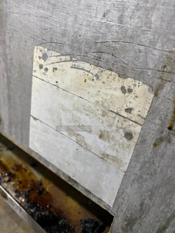 Southbend commercial stainless steel flat griddle with back and side splash, on legs. Used condition with visible wear.