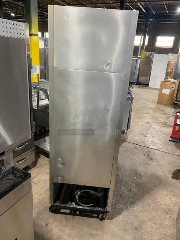 True T-23F commercial stainless steel reach-in freezer with built-in pan slides, on casters, showing exterior dents.