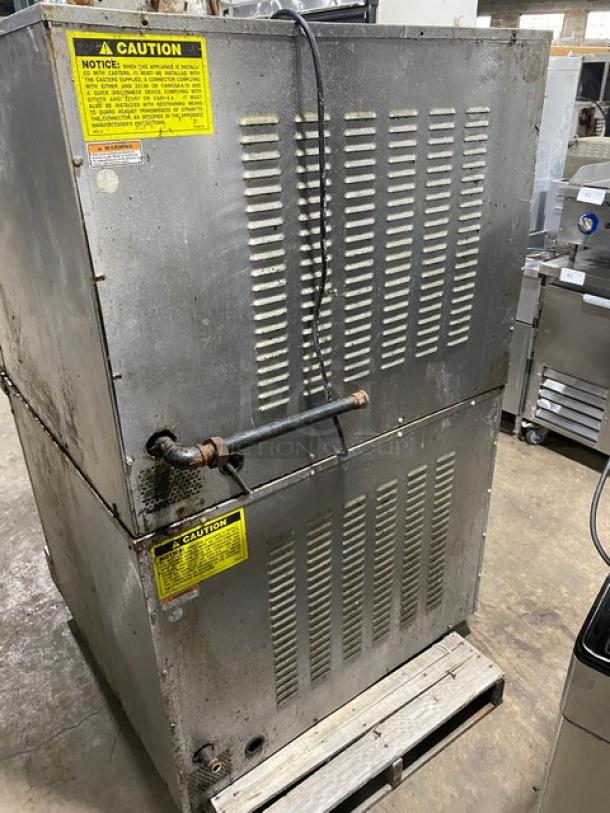 Vulcan commercial stainless steel natural gas double-stacked convection oven with thermostatic controls, wired racks, and casters. Visible caution labels.