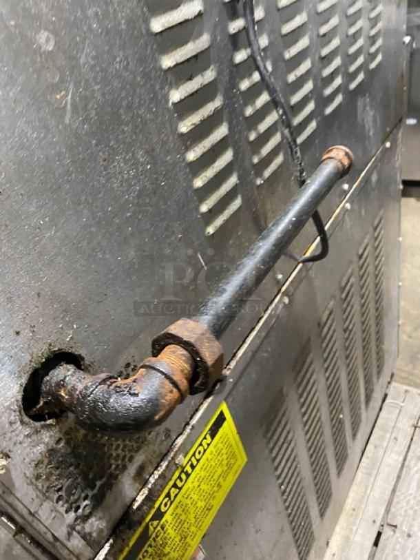 Back view of a Vulcan commercial stainless steel double stacked convection oven. Visible gas pipe connection and safety label. Rust observed on pipe fittings.