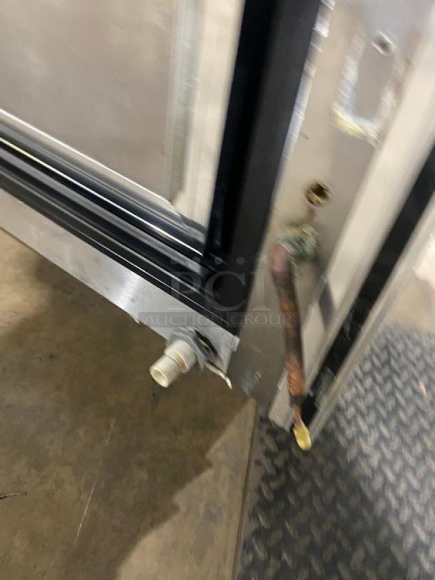 Close-up of the Leader NRHD96R refrigerated display case's lower section, showcasing the stainless steel build and plumbing connections.