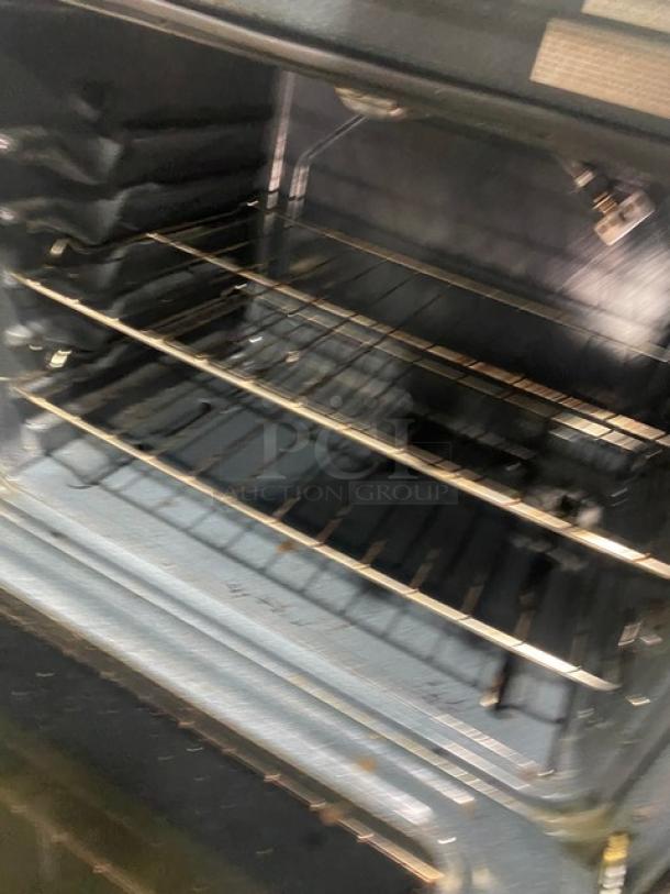 Amana commercial stainless steel/black natural gas 4-burner range/oven combo with digital controls and wired oven rack.