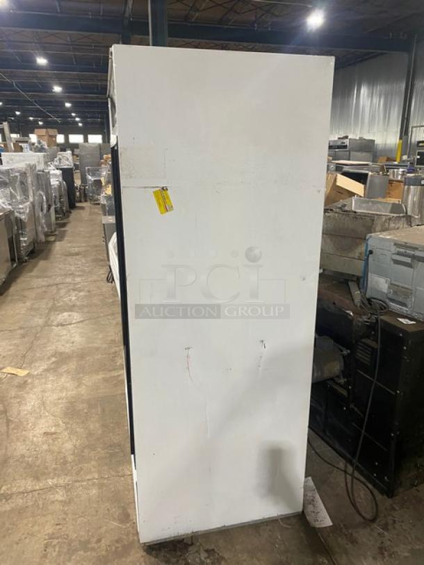 Beverage-Air commercial refrigerator, Model MT45, white, double glass sliding doors, side view, industrial setting.