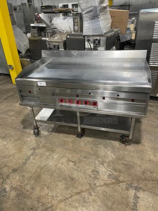 Commercial stainless steel natural gas countertop flat griddle with thermostatic controls, back and side splash, undershelf equipment stand, on casters.