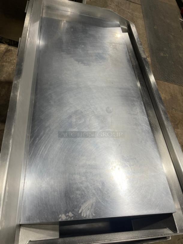 Commercial stainless steel natural gas countertop flat griddle with thermostatic controls, back and side splash, undershelf stand, on casters.