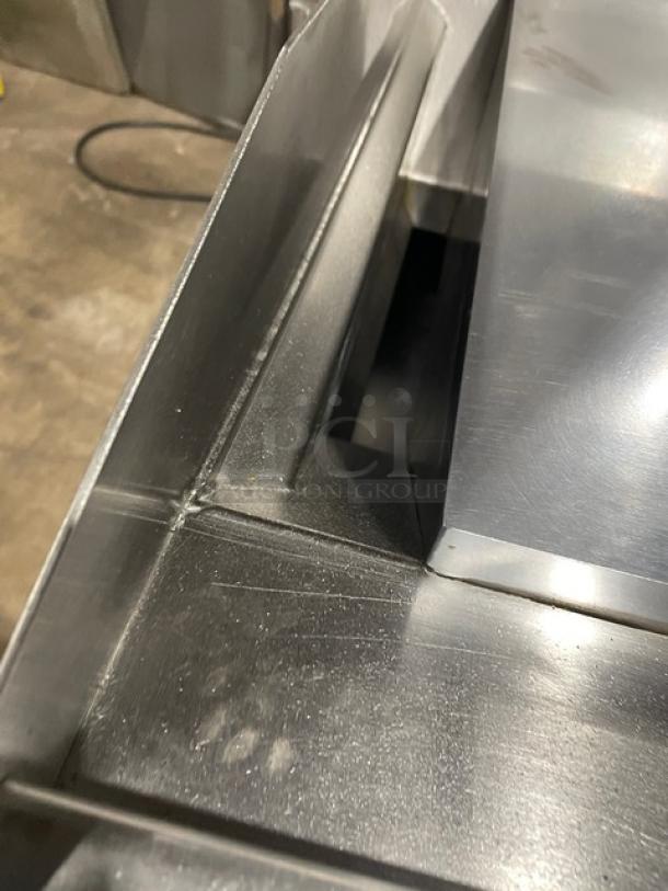 Commercial stainless steel flat griddle, natural gas powered, with thermostatic controls. Includes back/side splash and undershelf stand on casters.