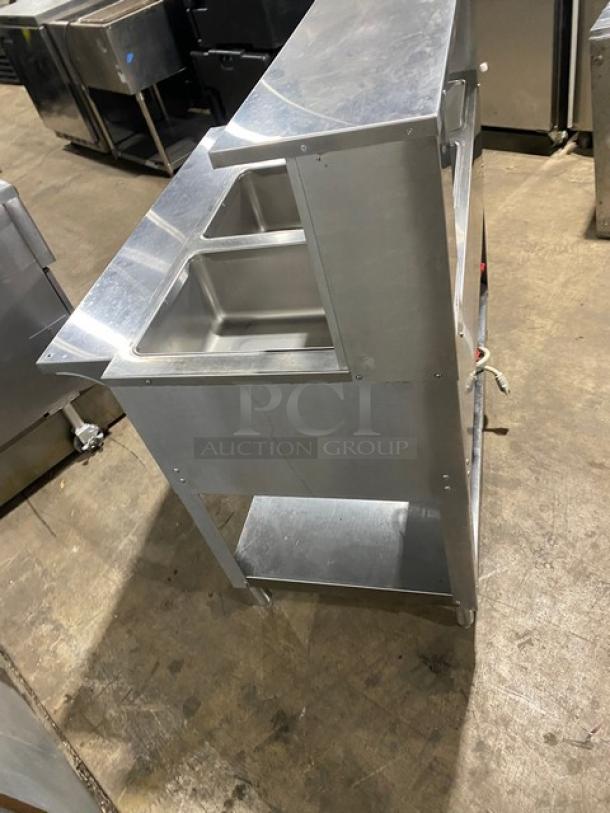 Duke AeroHot Series E303SWM 3-Well Stainless Steel Steam Table, 208V, with serve-over shelf, tray slide, undershelf, on legs.