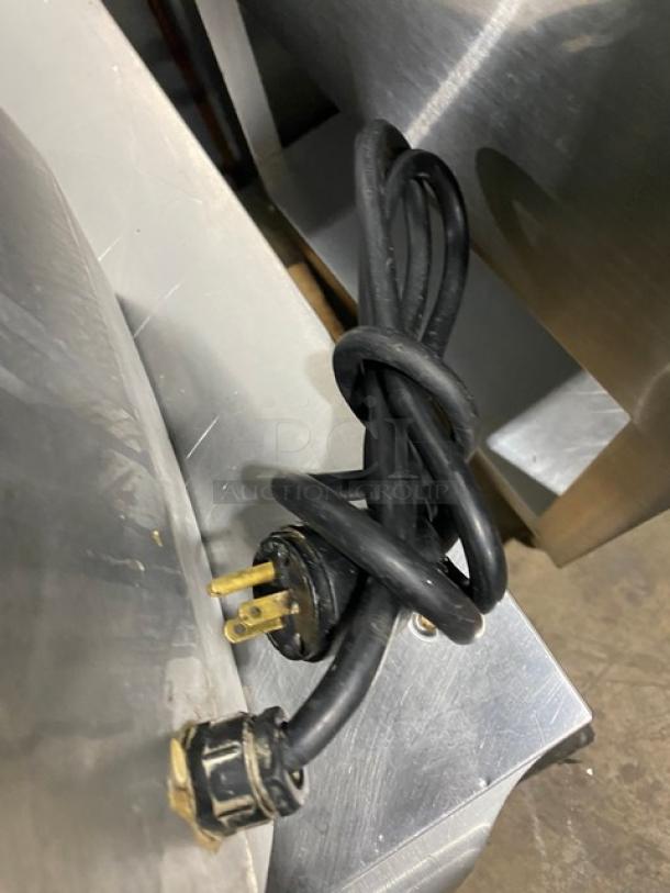 Robot Coupe R602VV food processor power cord, three-prong plug, black, coiled, shown on stainless steel surface.