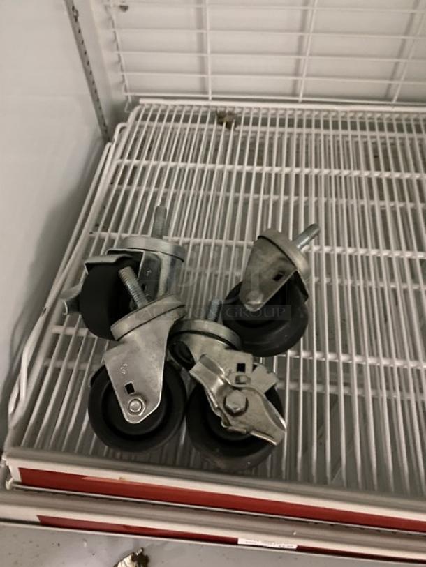 Kool-It Signature Series commercial freezer casters on poly coated wire racks. Model 163LX46FB, 2021, black glass doors.