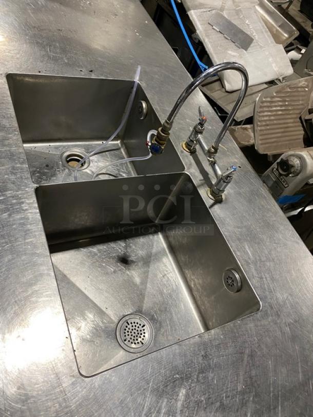 Custom commercial stainless steel double compartment sink with goose neck swivel faucet and enclosed cabinet base on legs.