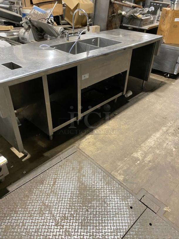 Custom commercial stainless steel double compartment sink workstation with gooseneck swivel faucet and enclosed cabinet base.