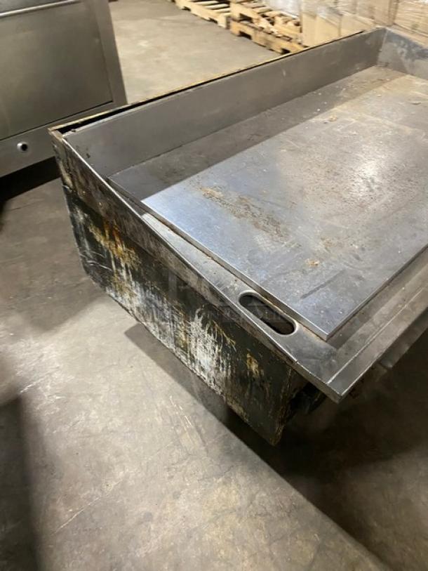 Commercial stainless steel gas-powered countertop flat griddle with thermostatic controls, side and back splash. Worn condition.