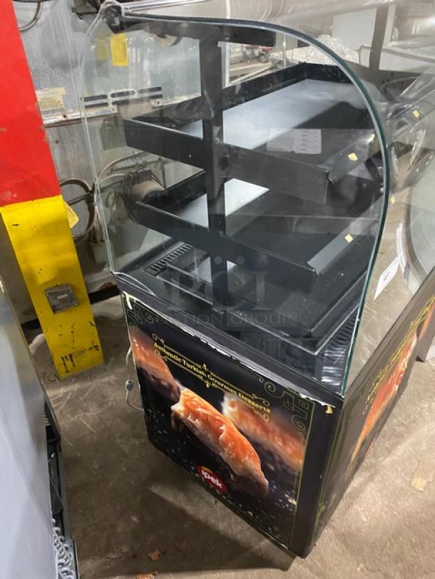 Commercial black curved glass refrigerated display case, multi-tier shelves for desserts. Bakery merchandiser with vibrant graphics.