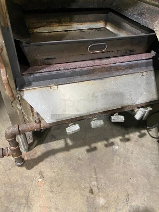 Commercial stainless steel smokehouse with right-side hinged door, on legs. Natural gas powered. Visible rust and wear.