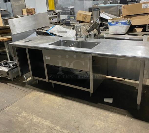 Custom commercial stainless steel double compartment sink workstation with gooseneck swivel faucet, enclosed cabinet base, on legs.