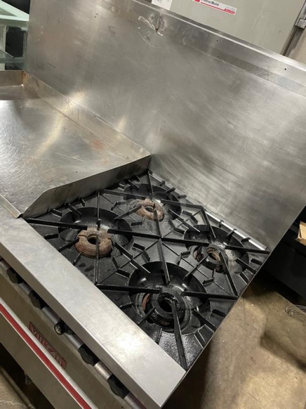 Vulcan commercial stainless steel flat griddle, 4-burner range with double oven combo, featuring backsplash and wired racks.