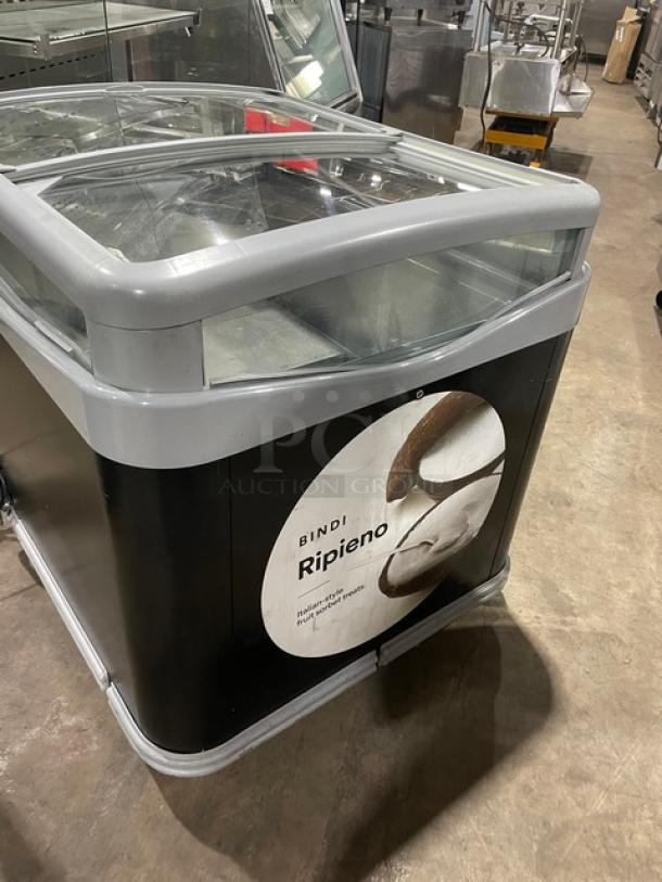 AHT commercial black glass top ice cream merchandiser display chest freezer with double sliding lid, on casters. Bindi Ripieno label.