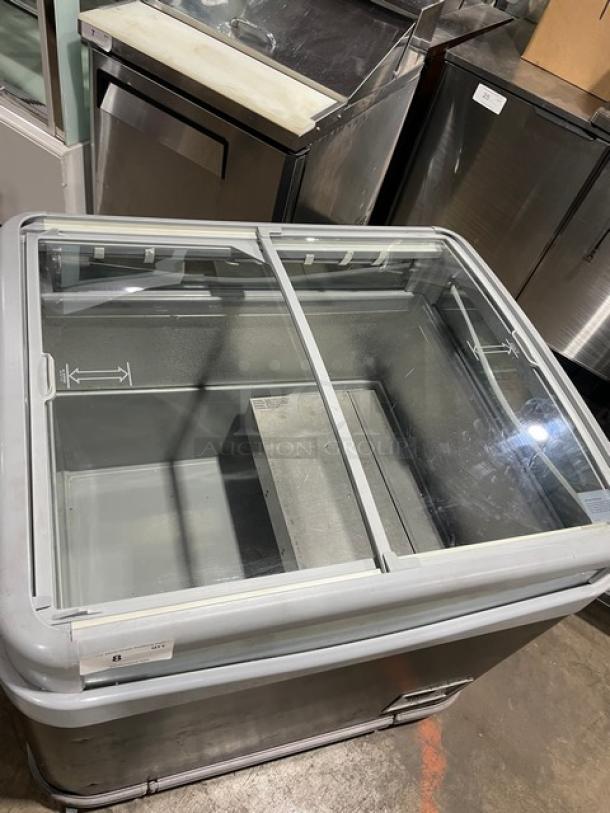 AHT commercial black glass top merchandiser freezer with double sliding lid on casters. Ideal for ice cream display.