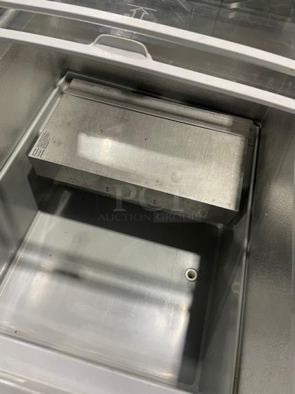 AHT commercial ice cream merchandiser with metal interior, double sliding glass lid, on casters. Clean condition.