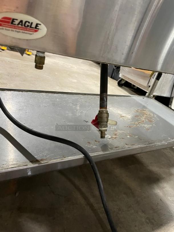 Eagle Group commercial stainless steel gas-powered steam table with three pans, tray slide, single undershelf, and legs; visible wear.
