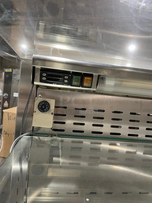 Commercial stainless steel refrigerated display case with straight glass, adjustable shelves, and control panel.