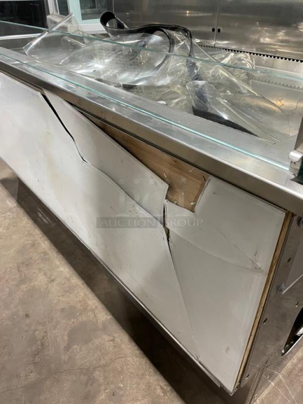 Commercial stainless steel refrigerated display case with straight glass, adjustable shelves, visible damage on side panel.